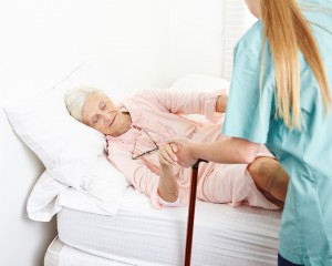 Krankenschwester hilft Seniorin beim Aufstehen