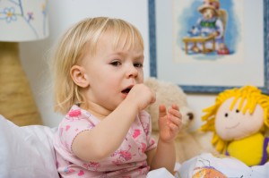 little sick girl in bed with cough