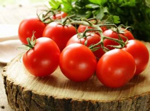 branch of ripe red tomato on a wooden stump